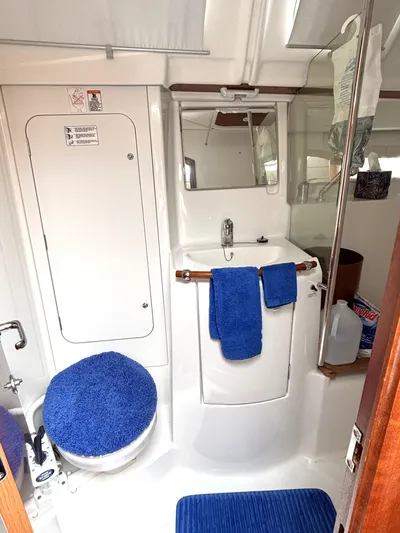Windsome Yacht Photos Pics Interior of 2006 Beneteau Oceanis 373 yacht bathroom with blue accents and compact design.