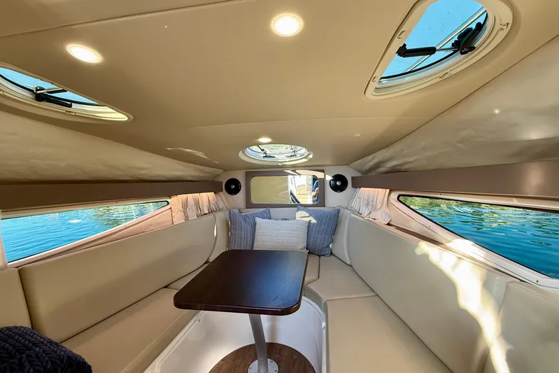 My Particular Harbor Yacht Photos Pics 2018 Regal 28 Express cabin interior with seating, table, and windows overlooking water.