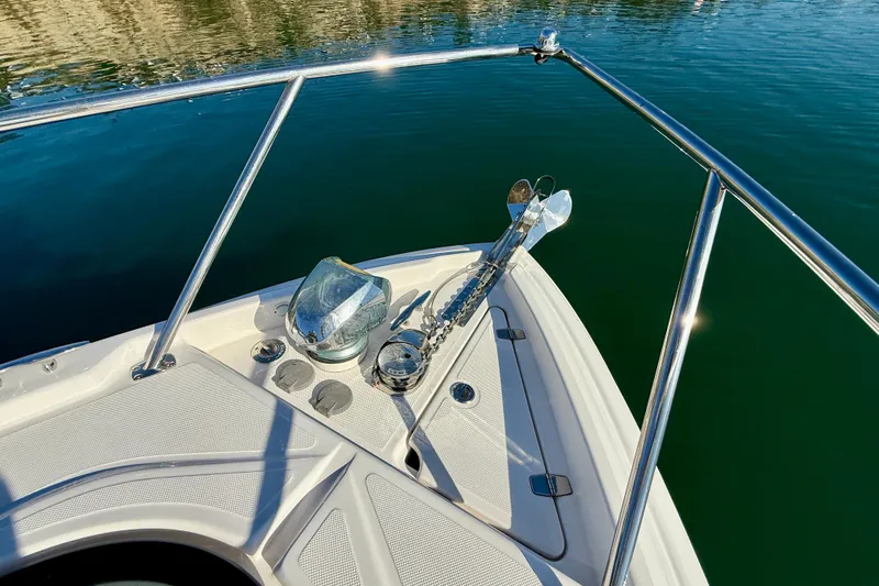 My Particular Harbor Yacht Photos Pics Bow of 2018 Regal 28 Express boat with anchor and railing on calm water.