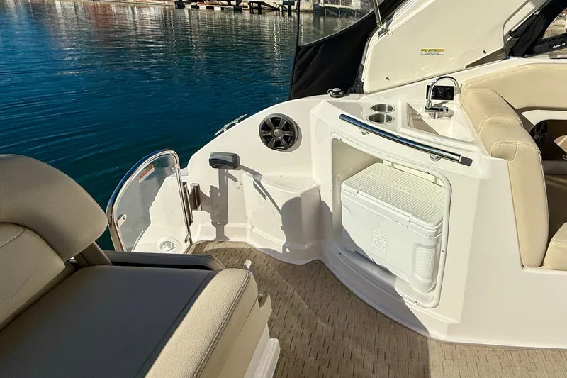 My Particular Harbor Yacht Photos Pics 2018 Regal 28 Express boat interior with seating, cooler, and cup holders by the water.