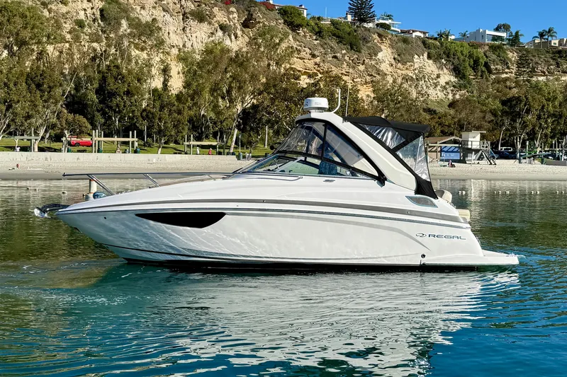 My Particular Harbor Yacht Photos Pics 2018 Regal 28 Express boat on calm water near a scenic shoreline.