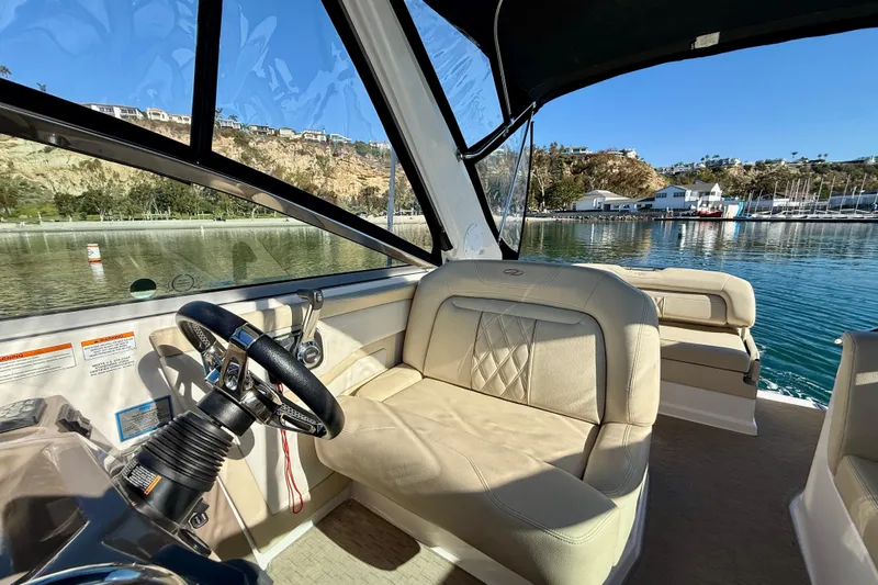My Particular Harbor Yacht Photos Pics Interior of 2018 Regal 28 Express boat with beige seating and steering wheel.