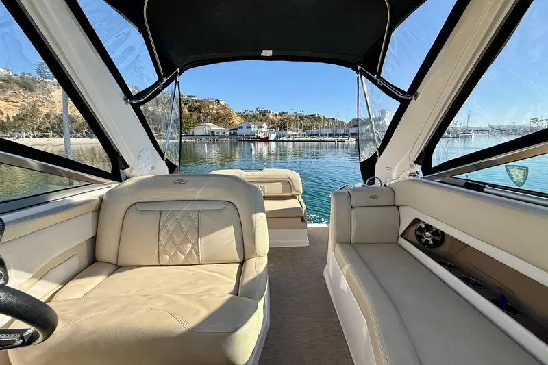 My Particular Harbor Yacht Photos Pics 2018 Regal 28 Express boat interior with beige seating, docked in a scenic marina.