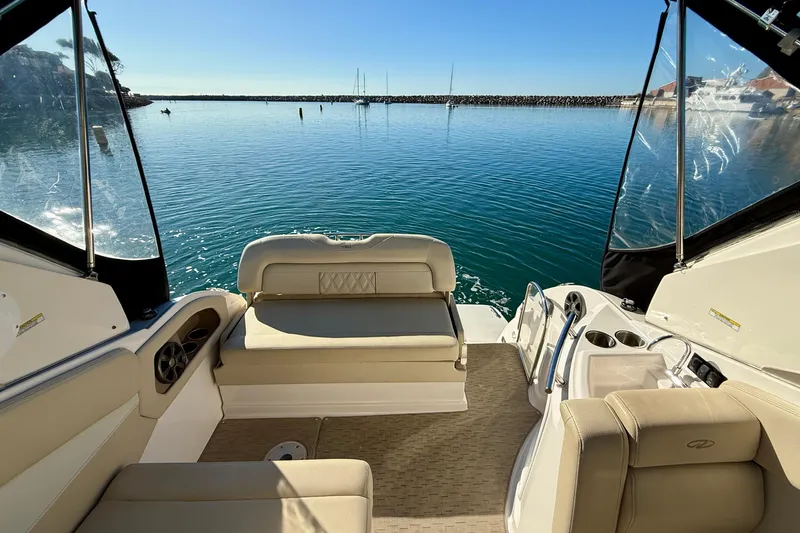 My Particular Harbor Yacht Photos Pics 2018 Regal 28 Express boat interior with seating, overlooking calm water and clear sky.
