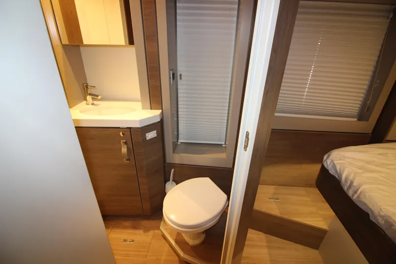  Yacht Photos Pics Compact bathroom in a 2022 Bali 4.6 model, featuring a toilet, sink, and shower.