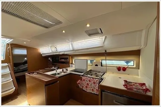  Yacht Photos Pics Interior of 2020 Jeanneau Sun Odyssey 490 yacht, featuring modern kitchen and dining area.