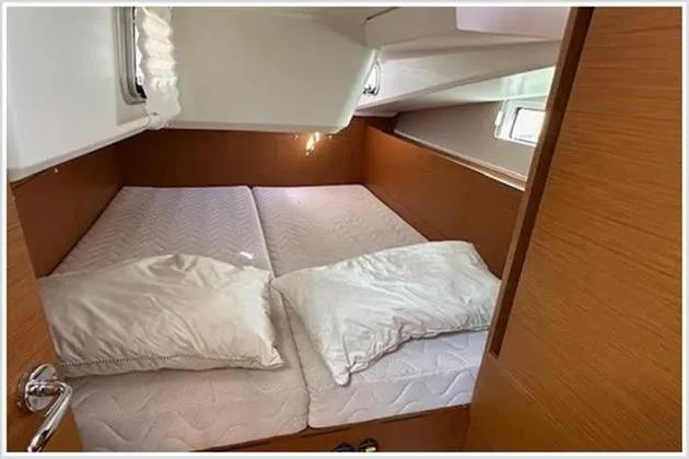  Yacht Photos Pics Cozy cabin interior of 2020 Jeanneau Sun Odyssey 490 yacht with double bed and pillows.
