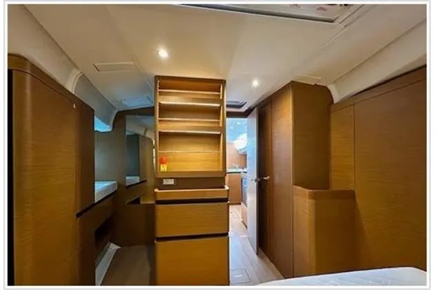  Yacht Photos Pics Interior of 2020 Jeanneau Sun Odyssey 490 yacht, featuring modern wood cabinetry and ambient lighting.