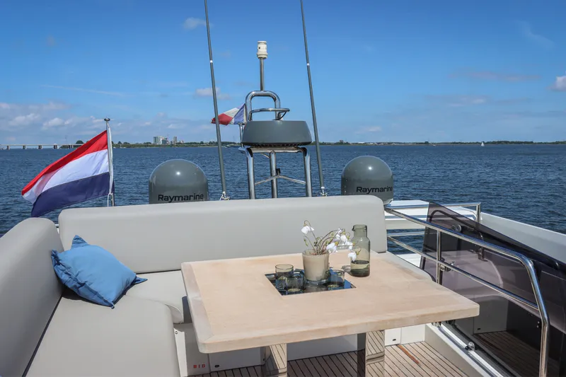  Yacht Photos Pics Luxurious 2021 Prestige 520 yacht deck with seating, table, and scenic water view.