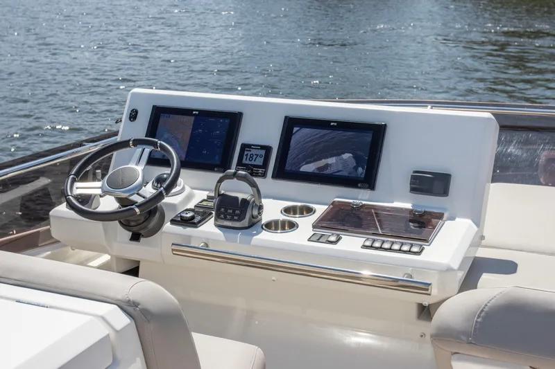  Yacht Photos Pics Control panel of a 2021 Prestige 520 yacht with navigation screens and steering wheel.