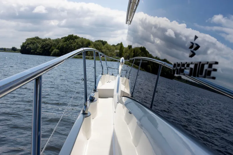  Yacht Photos Pics Prestige 520 yacht on a serene lake, reflecting sky and trees, 2021 model.
