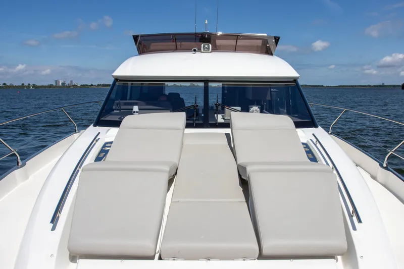  Yacht Photos Pics Luxury 2021 Prestige 520 yacht with sun loungers on deck, cruising on open water.