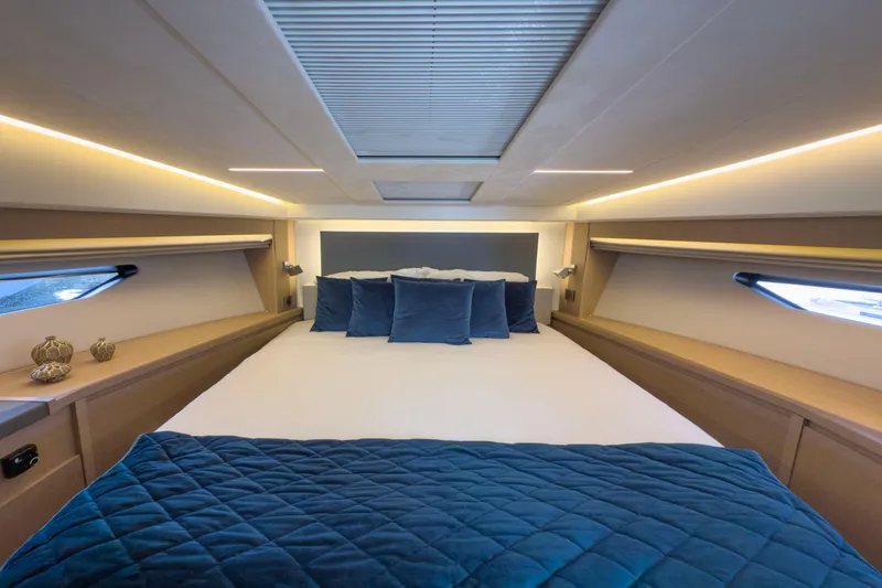  Yacht Photos Pics Luxurious bedroom interior of 2021 Prestige 520 yacht with modern design and blue accents.