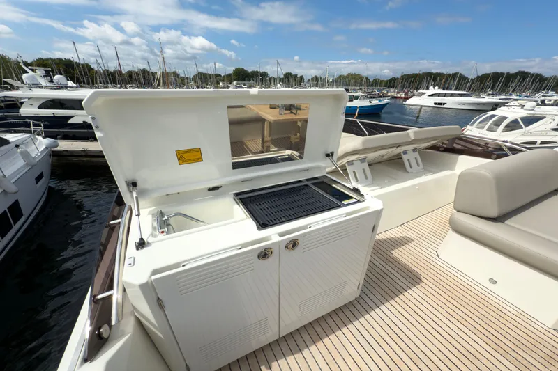  Yacht Photos Pics Outdoor kitchen on 2021 Prestige 520 yacht with grill and sink, docked at marina.