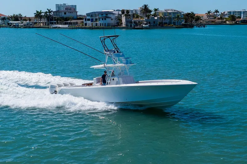  Yacht Photos Pics 2012 SeaVee 390B boat cruising on clear blue water near coastal homes.