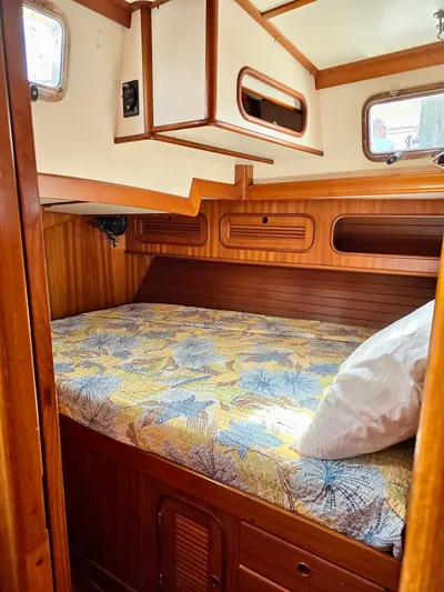 Circa Tempo Yacht Photos Pics Cozy cabin interior of 1991 Mason 44 sailboat with wooden finish and patterned bedding.