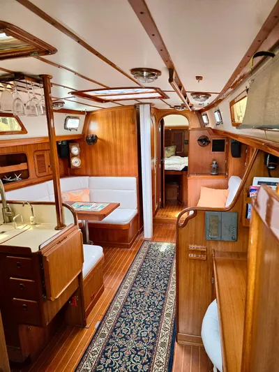 Circa Tempo Yacht Photos Pics Interior of a 1991 Mason 44 yacht with wooden furnishings and cozy seating area.