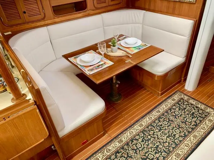Circa Tempo Yacht Photos Pics Cozy dining area in a 1991 Mason 44 yacht with elegant wood and white seating.