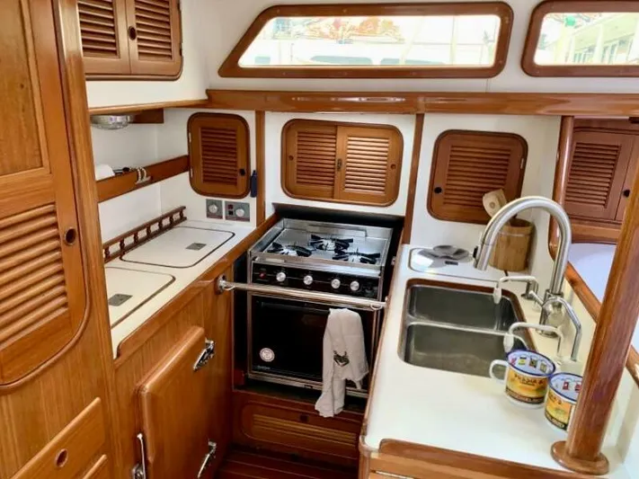 Circa Tempo Yacht Photos Pics Interior of a 1991 Mason 44 yacht kitchen with wooden cabinets and modern appliances.