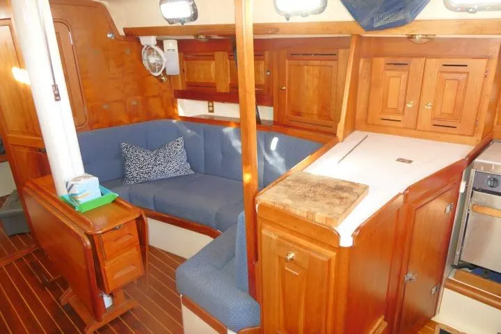 C Otter Yacht Photos Pics Interior of 2002 Tartan 3700 sailboat with wooden cabinetry and blue seating.