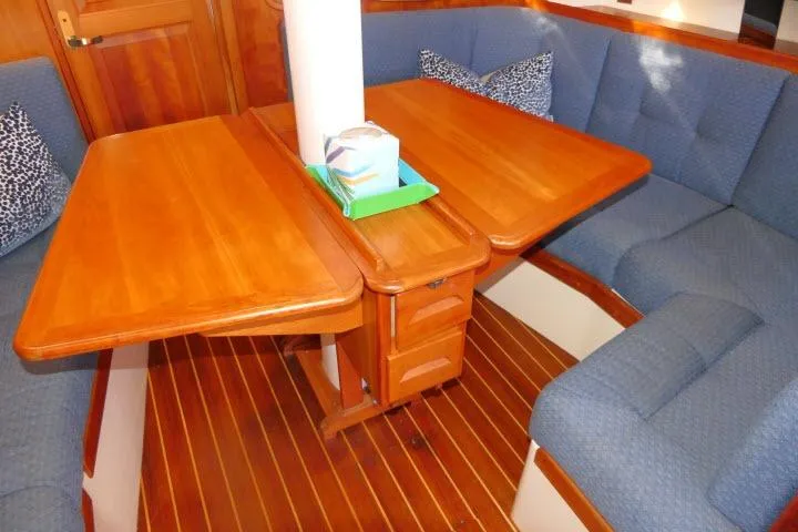 C Otter Yacht Photos Pics Cozy Tartan 3700 sailboat interior with wooden table and blue cushioned seating, 2002 model.