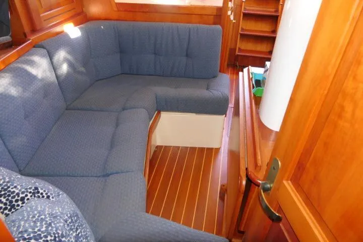 C Otter Yacht Photos Pics Cozy interior of 2002 Tartan 3700 sailboat with blue cushioned seating and wooden finish.