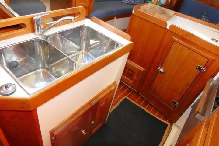 C Otter Yacht Photos Pics Galley area of 2002 Tartan 3700 yacht with dual sinks and wooden cabinetry.
