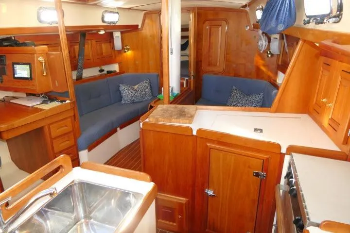 C Otter Yacht Photos Pics Interior of a 2002 Tartan 3700 sailboat with wood finish and blue seating.