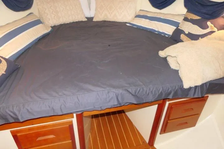 C Otter Yacht Photos Pics Cozy cabin bed in 2002 Tartan 3700 sailboat with pillows and wooden drawers.