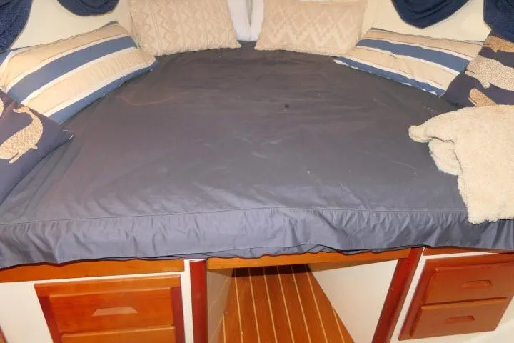 C Otter Yacht Photos Pics Cozy cabin bed in 2002 Tartan 3700 yacht with striped pillows and wooden drawers.