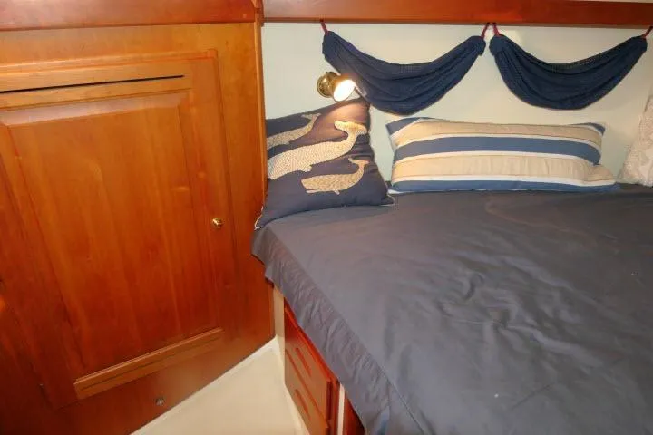 C Otter Yacht Photos Pics Cozy cabin interior of 2002 Tartan 3700 sailboat with nautical-themed bedding.