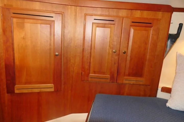 C Otter Yacht Photos Pics Wooden cabin interior of 2002 Tartan 3700 sailboat with blue cushioned seating.