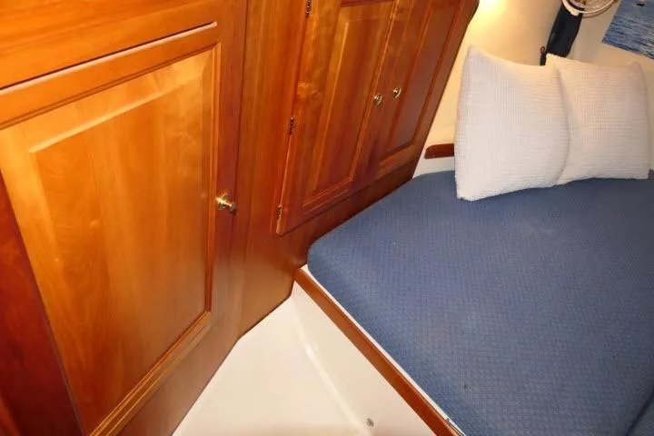 C Otter Yacht Photos Pics Cozy cabin interior of 2002 Tartan 3700 sailboat with wooden cabinetry and blue bedding.