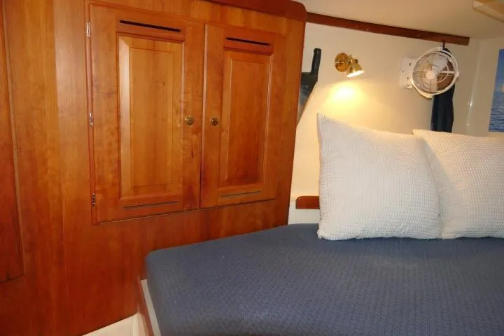 C Otter Yacht Photos Pics Cozy cabin interior of 2002 Tartan 3700 sailboat with wooden cabinets and blue bedding.