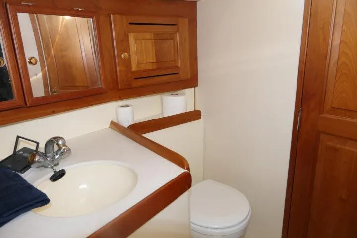 C Otter Yacht Photos Pics Bathroom interior of 2002 Tartan 3700 yacht with wooden cabinets and white fixtures.