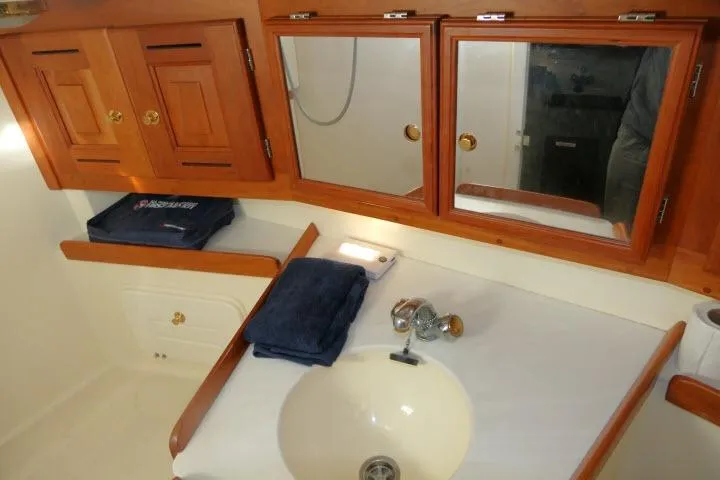 C Otter Yacht Photos Pics Bathroom vanity in 2002 Tartan 3700 yacht with wooden cabinets and mirror.