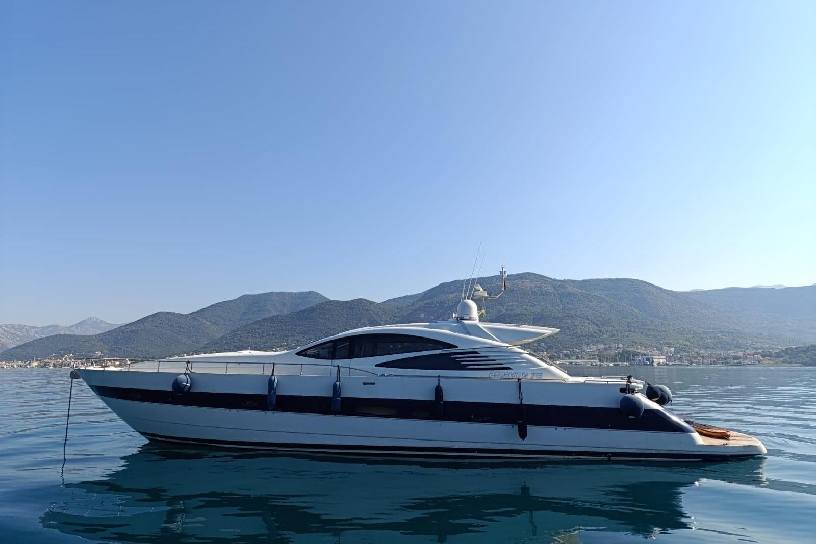 2005 Pershing 76 yacht on calm water with mountainous backdrop.