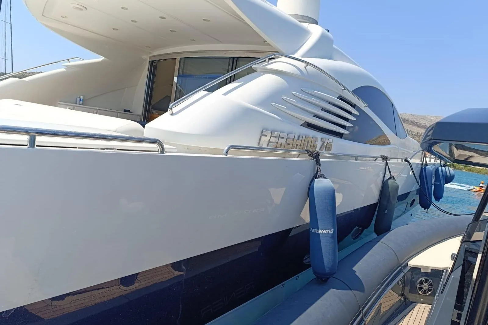 Luxury 2005 Pershing 76 yacht docked, featuring sleek design and modern amenities.