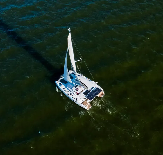 Blue Pearl Too Yacht Photos Pics Aerial view of 2017 Lagoon 42 catamaran sailing on open water.