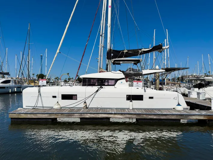 Blue Pearl Too Yacht Photos Pics 2017 Lagoon 42 catamaran docked at marina under clear blue sky.