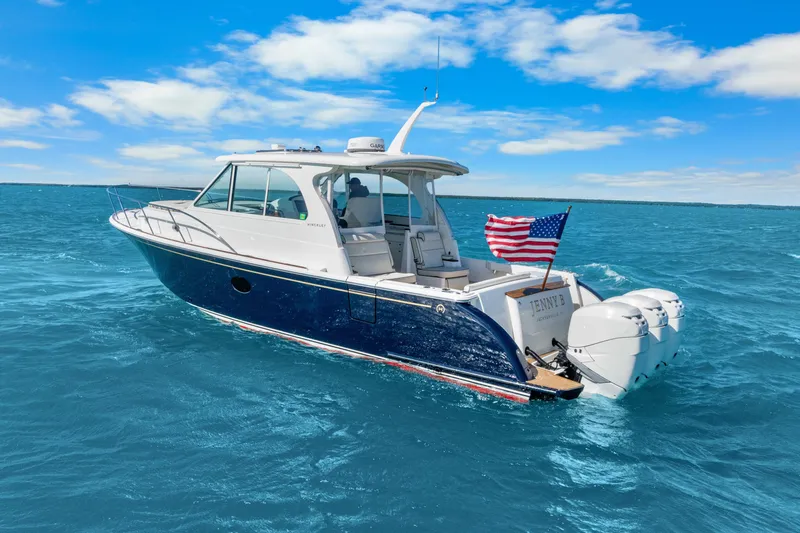 Jenny B Yacht Photos Pics 2021 Hinckley Sport Boat 40 X cruising on blue ocean with American flag.