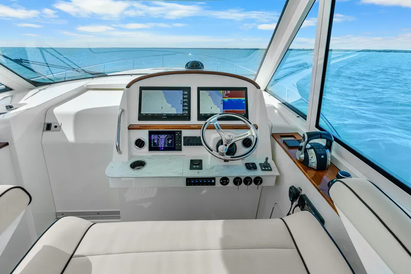 Jenny B Yacht Photos Pics Helm of 2021 Hinckley Sport Boat 40 X with navigation screens and steering wheel.