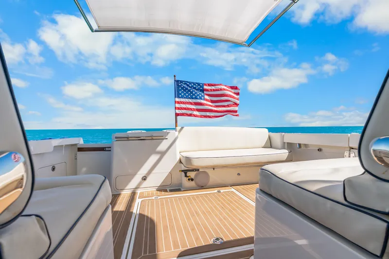 Jenny B Yacht Photos Pics Hinckley Sport Boat 40 X 2021, luxury deck view with American flag, ocean backdrop.