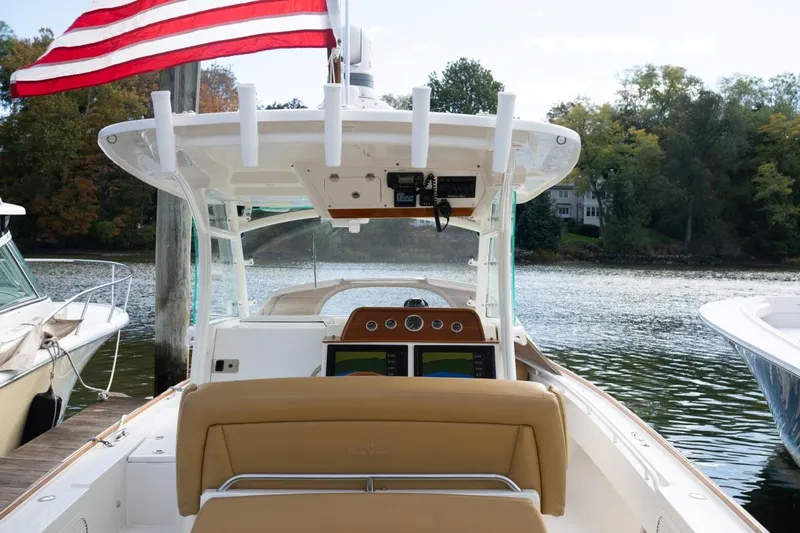 Minnow Yacht Photos Pics 2016 Hunt Yachts 32 Center Console at dock, American flag, serene waterfront setting.