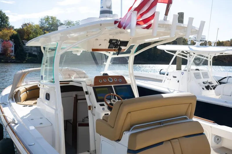 Minnow Yacht Photos Pics 2016 Hunt Yachts 32 Center Console boat with American flag, docked on a sunny day.