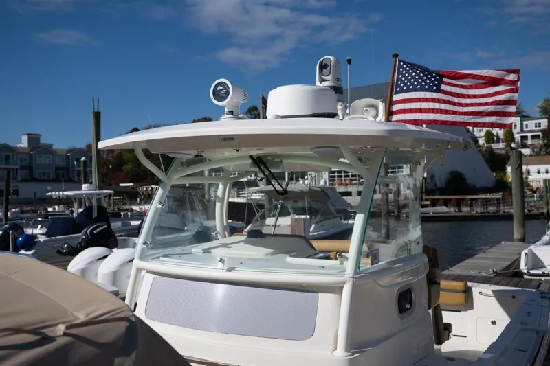 Minnow Yacht Photos Pics 2016 Hunt Yachts 32 Center Console docked with American flag, marina background.