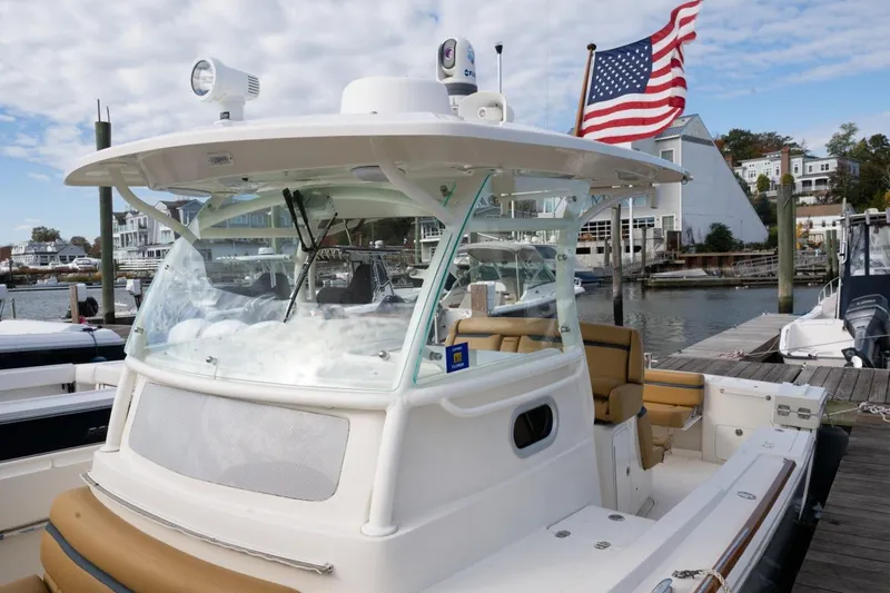 Minnow Yacht Photos Pics 2016 Hunt Yachts 32 Center Console docked, featuring American flag and marina backdrop.