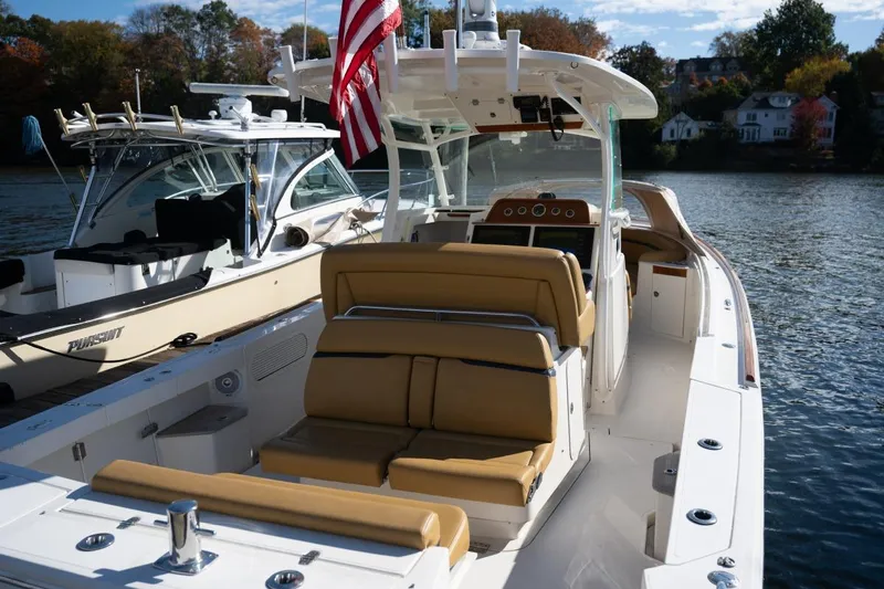 Minnow Yacht Photos Pics 2016 Hunt Yachts 32 Center Console on water, featuring tan seating and American flag.