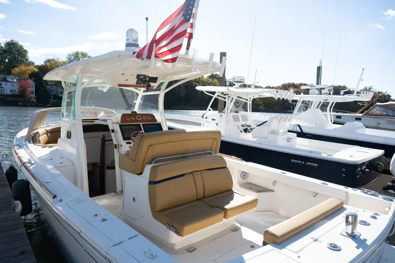 Minnow Yacht Photos Pics 2016 Hunt Yachts 32 Center Console docked, featuring tan seating and American flag.