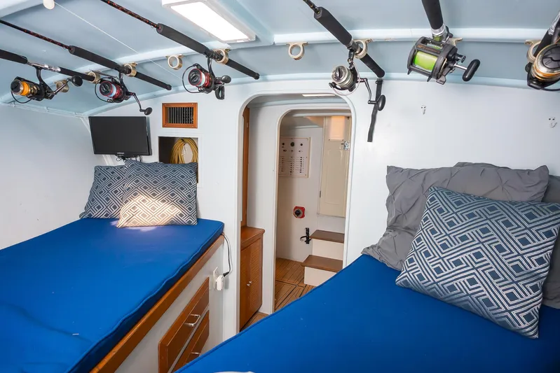 Moby Yacht Photos Pics Interior of 1987 Custom Carolina Island Boatworks 34 Express with twin beds and fishing rods.